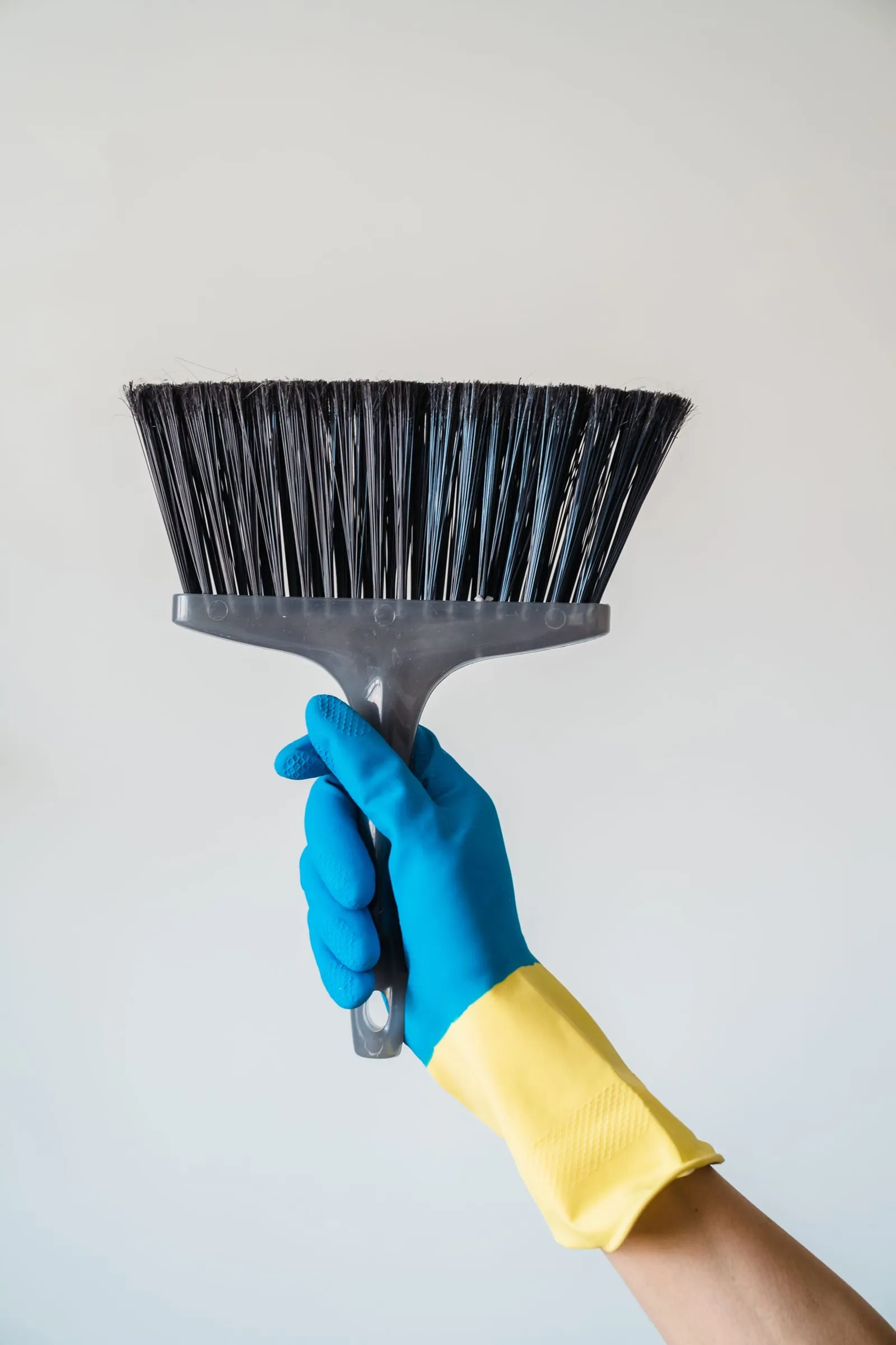 Gloved hand holding a broom, ready to start a job