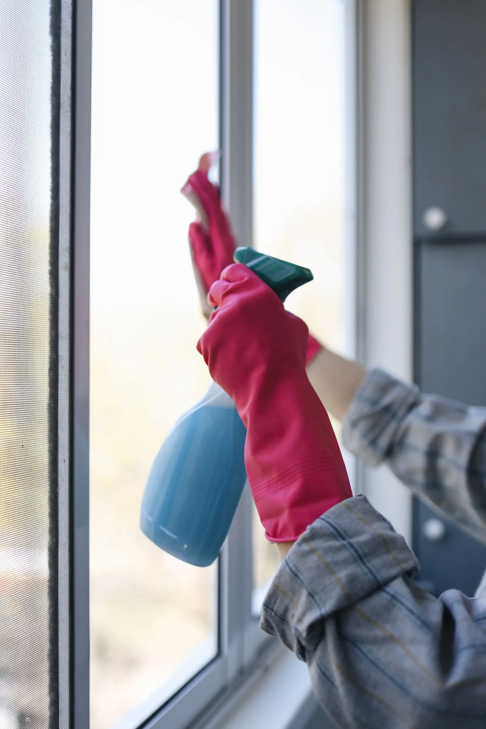 Window glass being sprayed and cleaned in natural daylight
